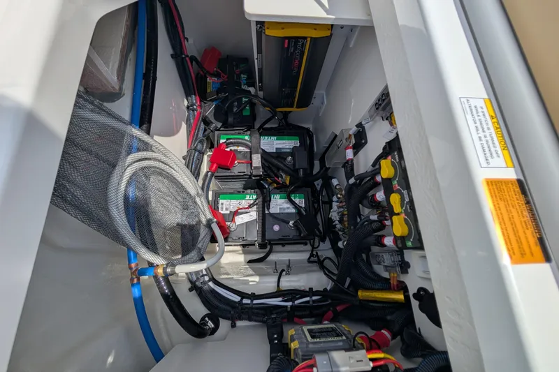 Slide: The Image of 2025 Sea Ray SDX 250 boat battery compartment with wiring and components. - 35