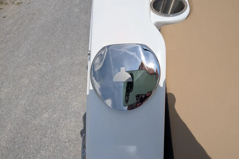 Slide: The Image of Chrome fuel cap on 2025 Sea Ray SDX 250 boat, with beige seating and cup holder. - 37