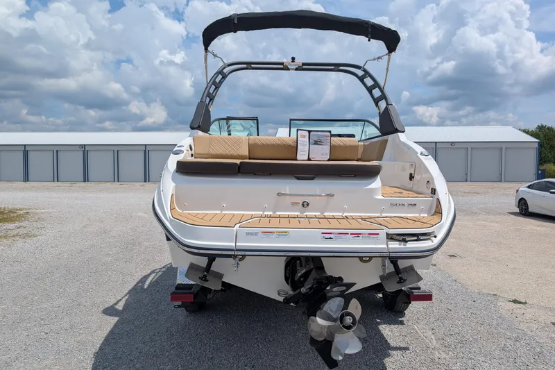 Slide: The Image of 2025 Sea Ray SDX 250 boat, rear view, parked outdoors under cloudy sky. - 7