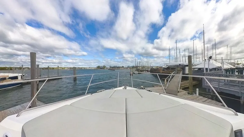 Slide: The Image of Bow view of 2018 Princess S60 yacht docked at a marina under a partly cloudy sky. - 14