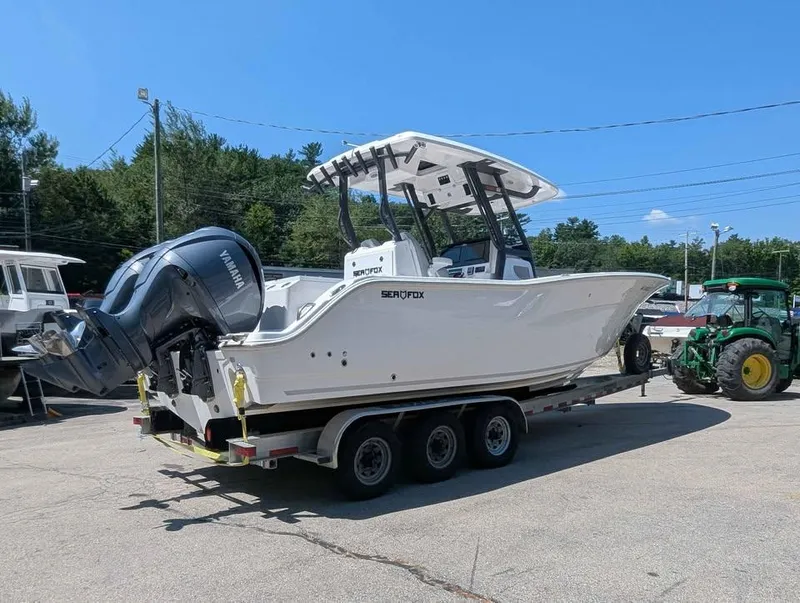 Slide: The Image of 2024 Sea Fox 288 Commander boat on trailer with Yamaha engines, parked outdoors. - 2