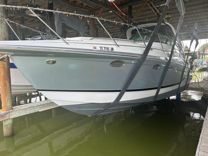 The Image of 2007 Formula 31 PC boat docked in a marina, partially lifted above water. - 0