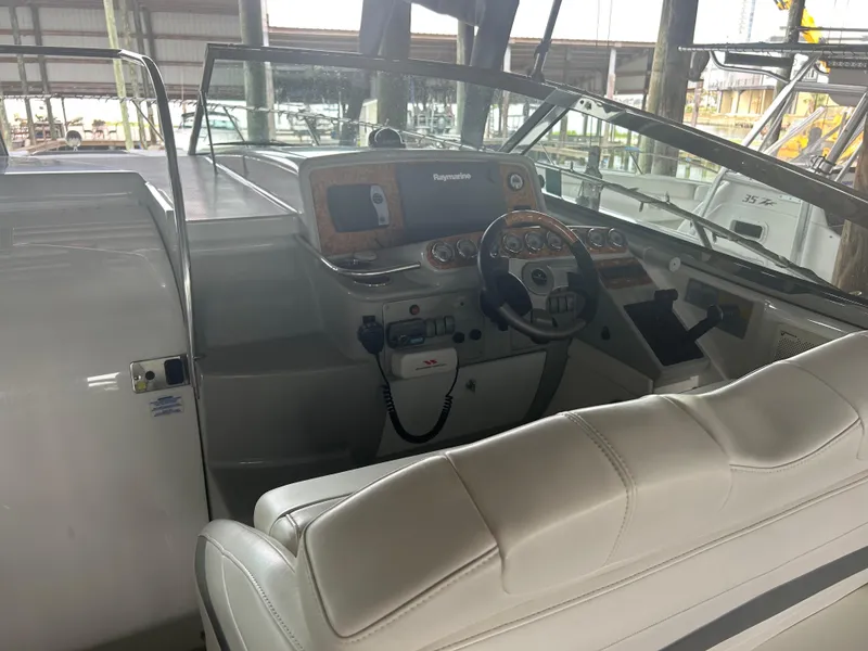 Slide: The Image of 2007 Formula 31 PC boat cockpit with steering wheel and control panel in marina setting. - 12
