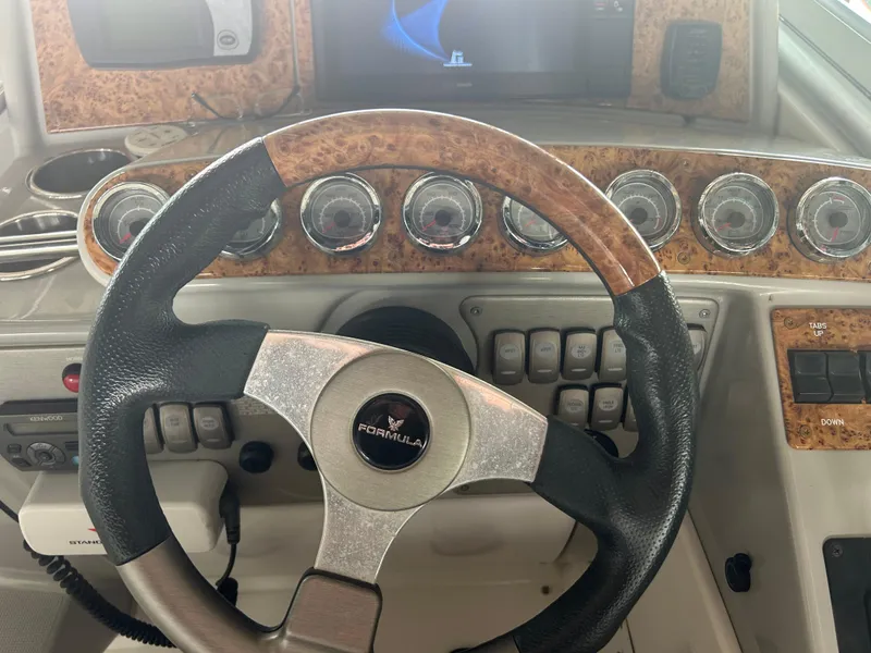 Slide: The Image of Steering wheel and dashboard of a 2007 Formula 31 PC boat with wood accents. - 18
