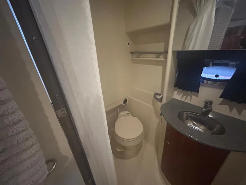 Slide: The Image of 2007 Formula 31 PC boat bathroom with toilet, sink, and porthole window. - 28