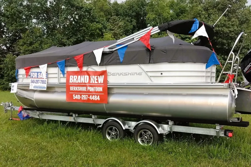 Slide: The Image of 2024 Berkshire 22RFX CTS pontoon boat for sale, covered and decorated with flags. - 0