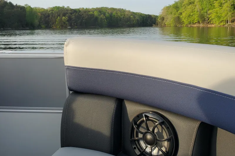 Slide: The Image of 2024 Berkshire 22RFX CTS boat interior with speaker, lake view, and lush green trees. - 7