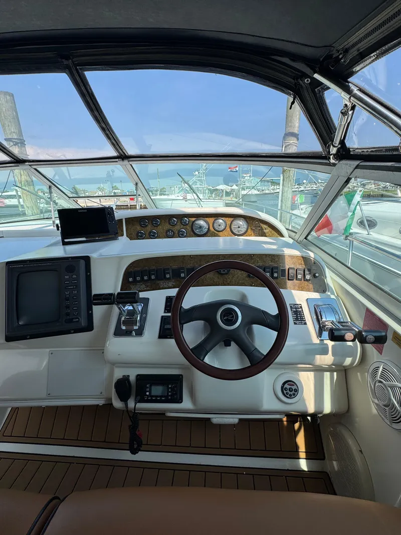 Slide: The Image of 1995 Sea Ray 370 Sundancer helm with steering wheel, gauges, and navigation equipment. - 11
