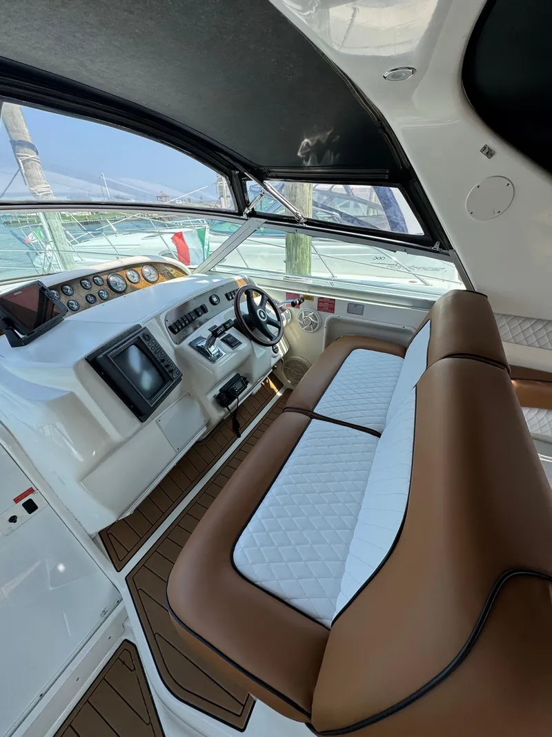 Slide: The Image of 1995 Sea Ray 370 Sundancer helm with brown and white seating, modern controls, and wood accents. - 16