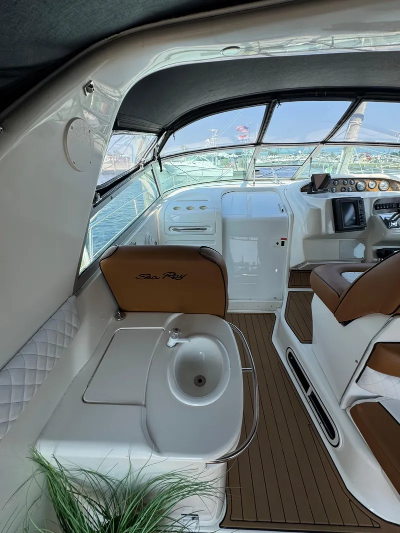Slide: The Image of 1995 Sea Ray 370 Sundancer interior with helm, seating, and sink, showcasing luxury boat design. - 19