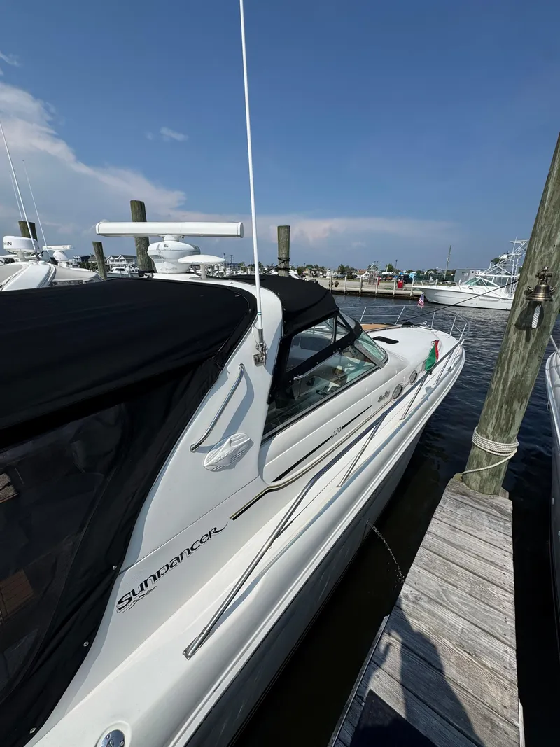 Slide: The Image of 1995 Sea Ray 370 Sundancer docked at a marina under a clear blue sky. - 2