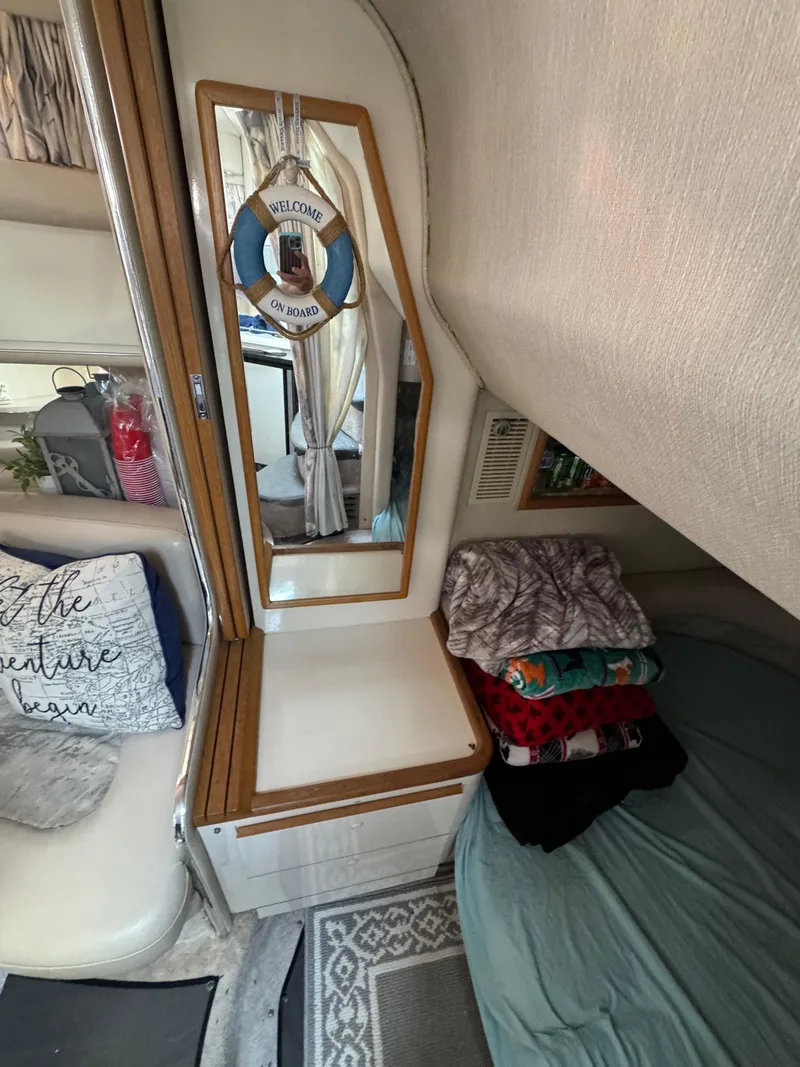 Slide: The Image of Interior of 1995 Sea Ray 370 Sundancer with mirror, folded clothes, and nautical decor. - 26