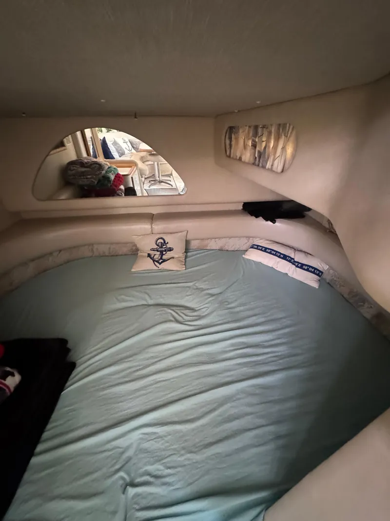 Slide: The Image of 1995 Sea Ray 370 Sundancer cabin interior with bed and nautical decor. - 27