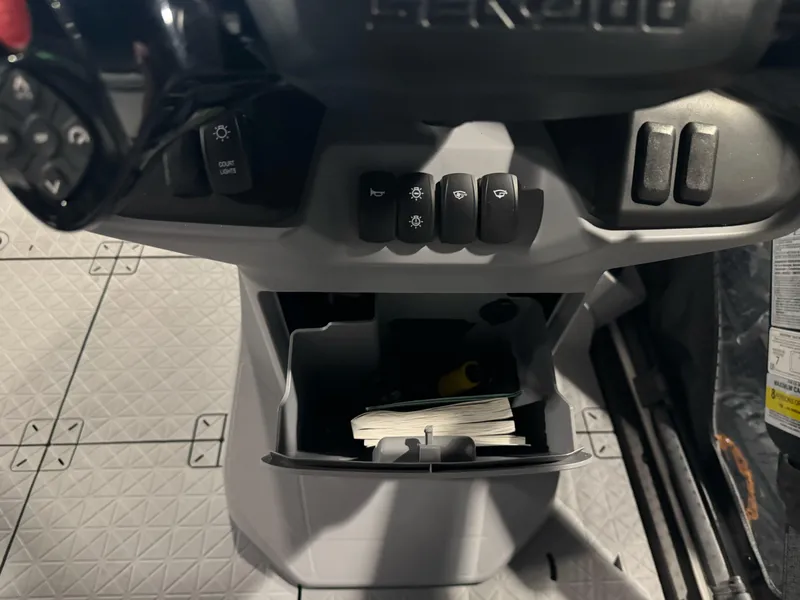 Slide: The Image of Control panel of 2025 Sea-Doo Switch Cruise 18 with storage compartment and switches. - 15