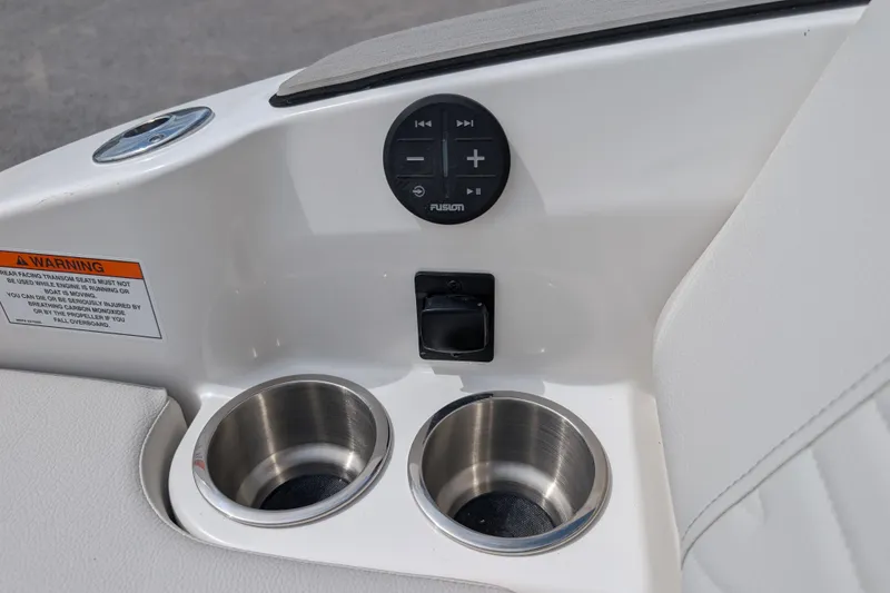 Slide: The Image of 2026 Sea Ray SDX 230 Surf boat interior with cup holders and audio controls. - 25