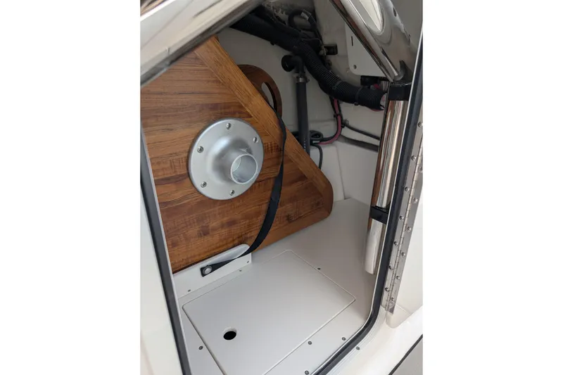Slide: The Image of Interior view of 2026 Sea Ray SDX 230 Surf boat compartment with wooden paneling. - 28