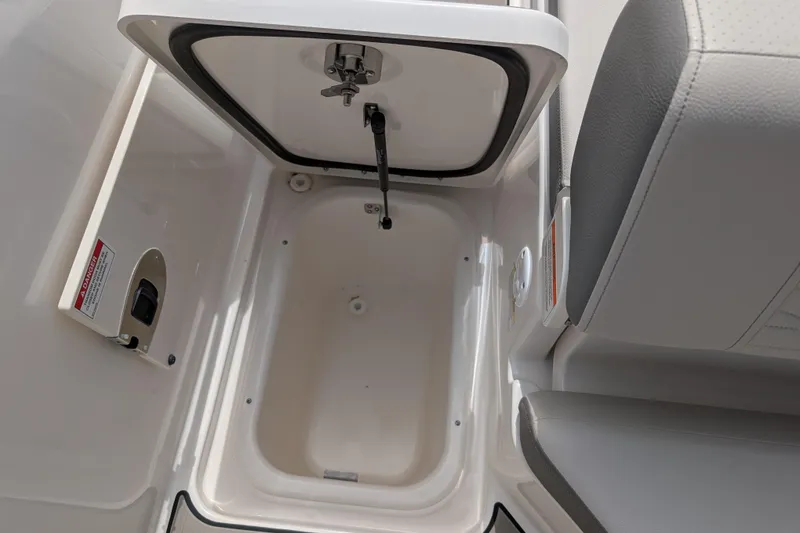 Slide: The Image of 2026 Sea Ray SDX 230 Surf storage compartment with open hatch and seating detail. - 34
