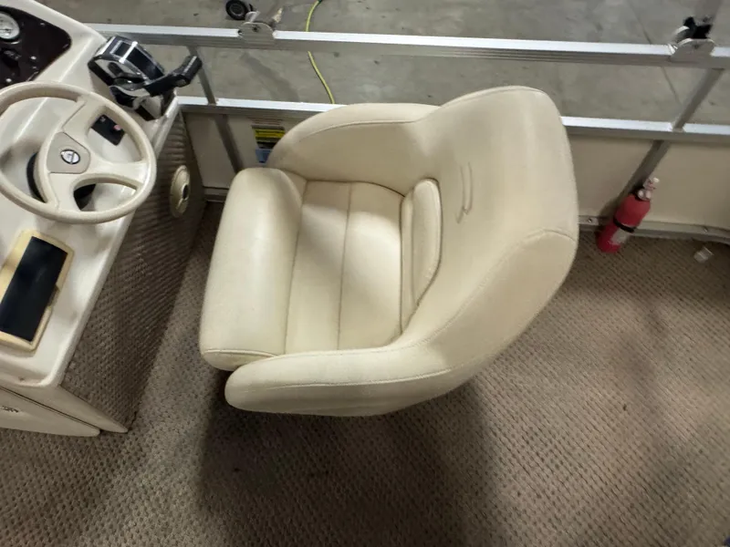 Slide: The Image of Beige captain's chair and steering wheel on a 2003 Bennington 205L boat. - 10