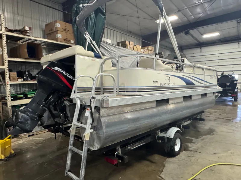 Slide: The Image of 2003 Bennington 205L pontoon boat with Mercury outboard motor in a garage setting. - 3