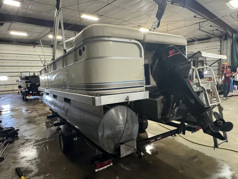 Slide: The Image of 2003 Bennington 205L pontoon boat in a garage, featuring a Mercury 50 outboard motor. - 4