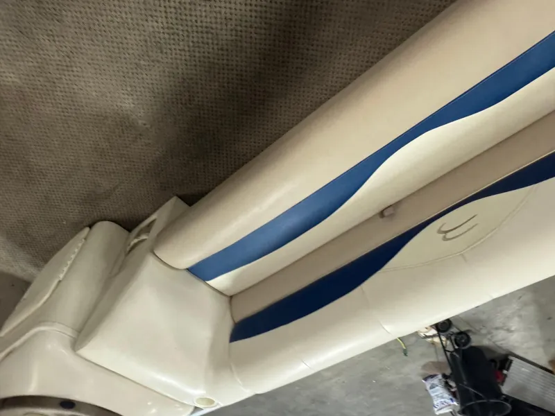 Slide: The Image of 2003 Bennington 205L boat seat with beige and blue upholstery, on a textured surface. - 6
