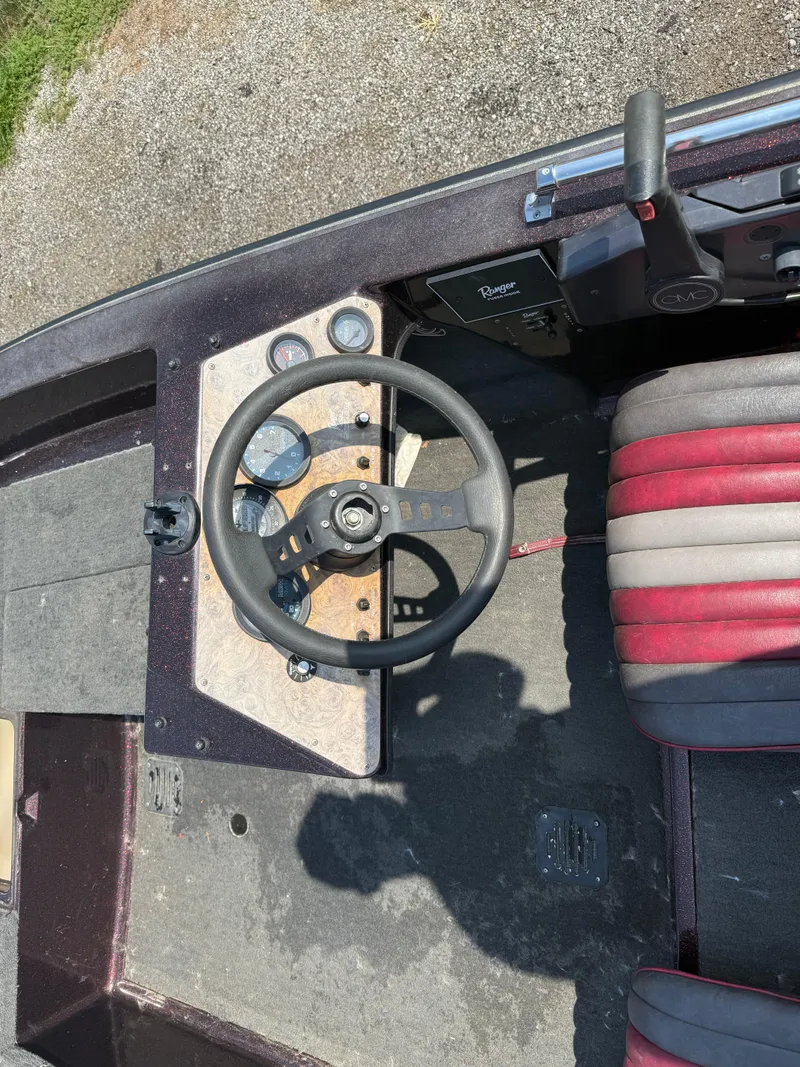 Slide: The Image of 1992 Ranger 320v boat cockpit with steering wheel and red-gray seat. - 10