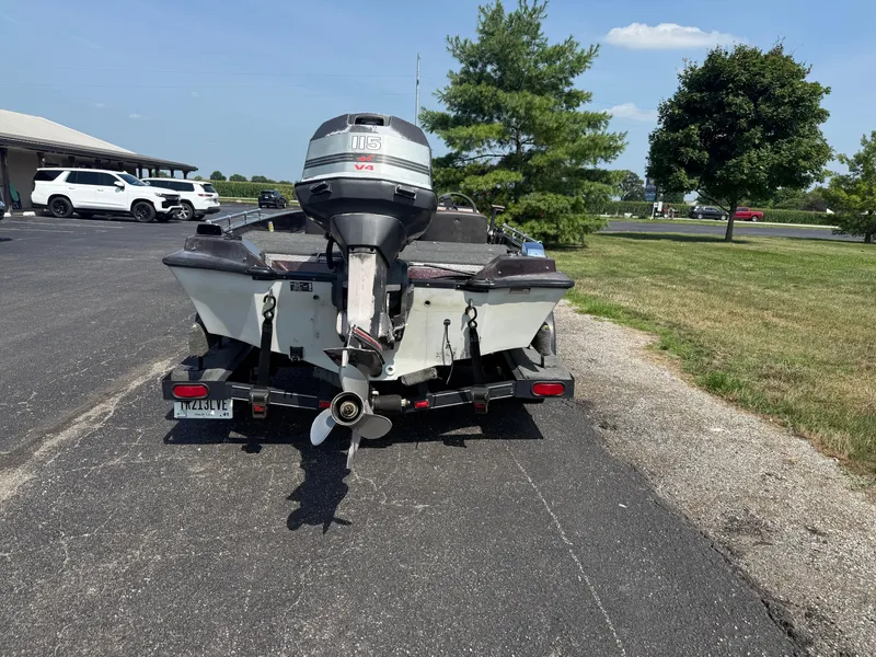Slide: The Image of 1992 Ranger 320v boat with outboard motor on trailer, parked outdoors. - 3