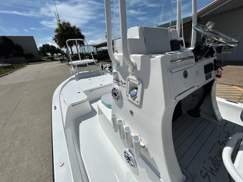 Slide: The Image of 2024 Shallow Sport 24 Modified V boat, white deck, sunny day, outdoor setting. - 15