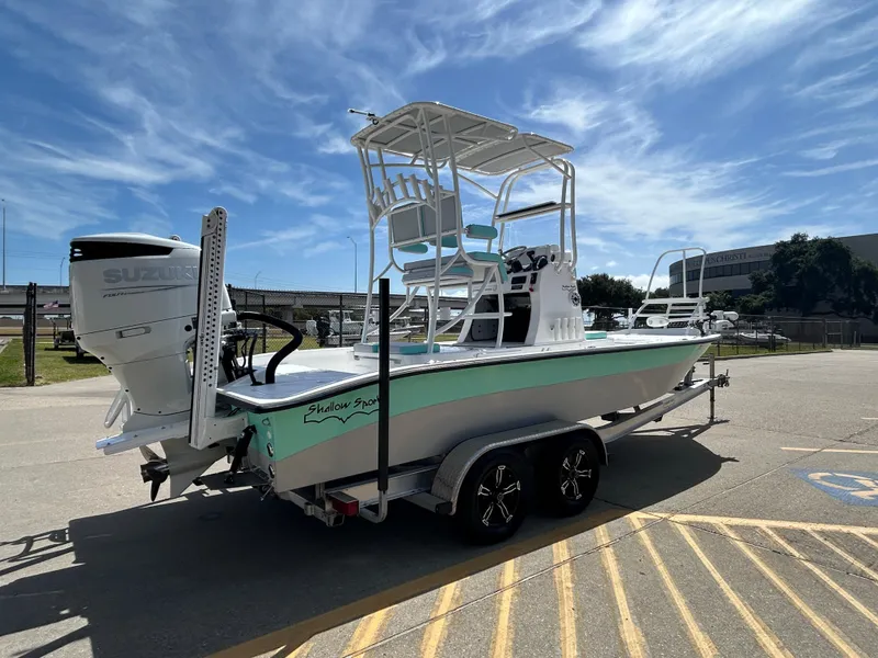 Slide: The Image of 2024 Shallow Sport 24 Modified V boat on trailer, featuring Suzuki outboard motor. - 3