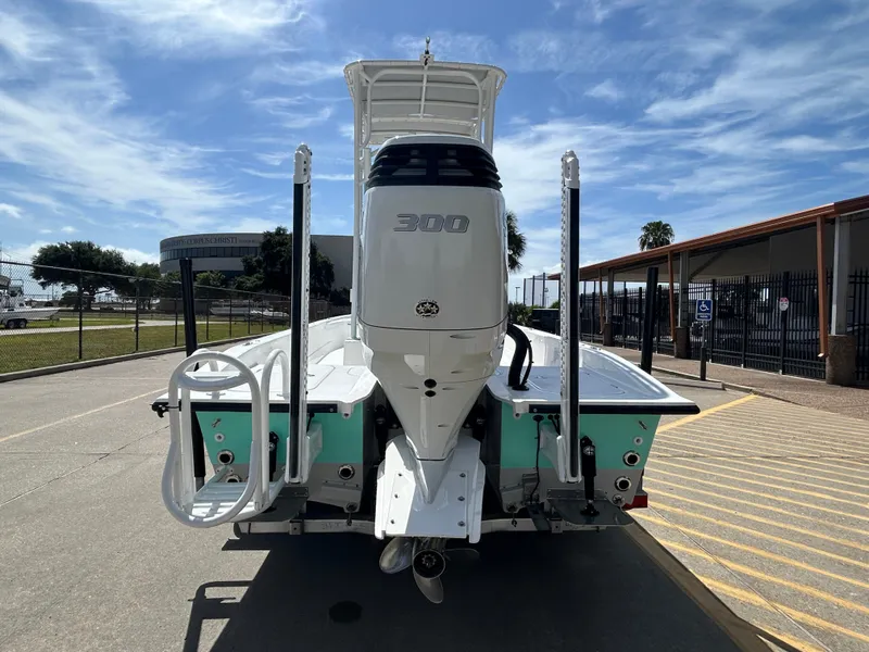 Slide: The Image of 2024 Shallow Sport 24 Modified V boat with powerful outboard motor, parked outdoors. - 4