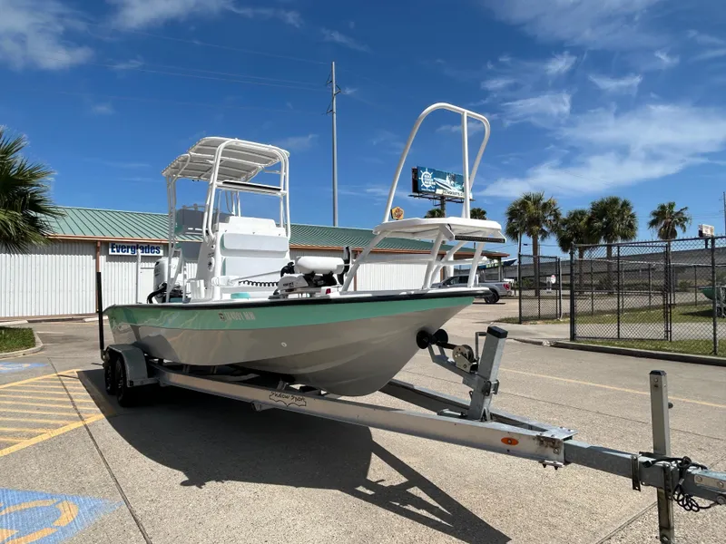 Slide: The Image of 2024 Shallow Sport 24 Modified V boat on trailer, parked outdoors under blue sky. - 6