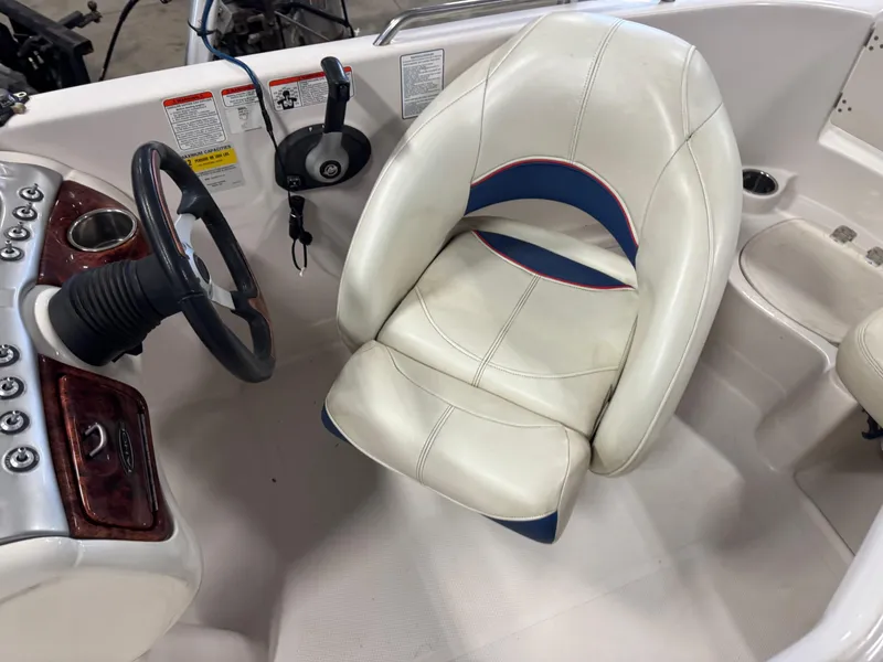 Slide: The Image of 2015 Tahoe 215 Xi boat cockpit with steering wheel and white captain's chair. - 11
