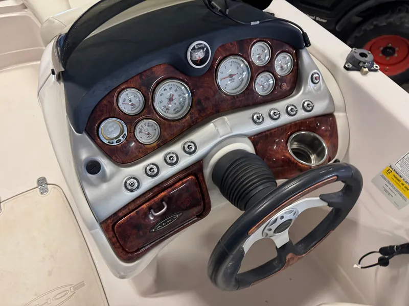 Slide: The Image of Dashboard of a 2015 Tahoe 215 Xi boat with gauges and steering wheel. - 12