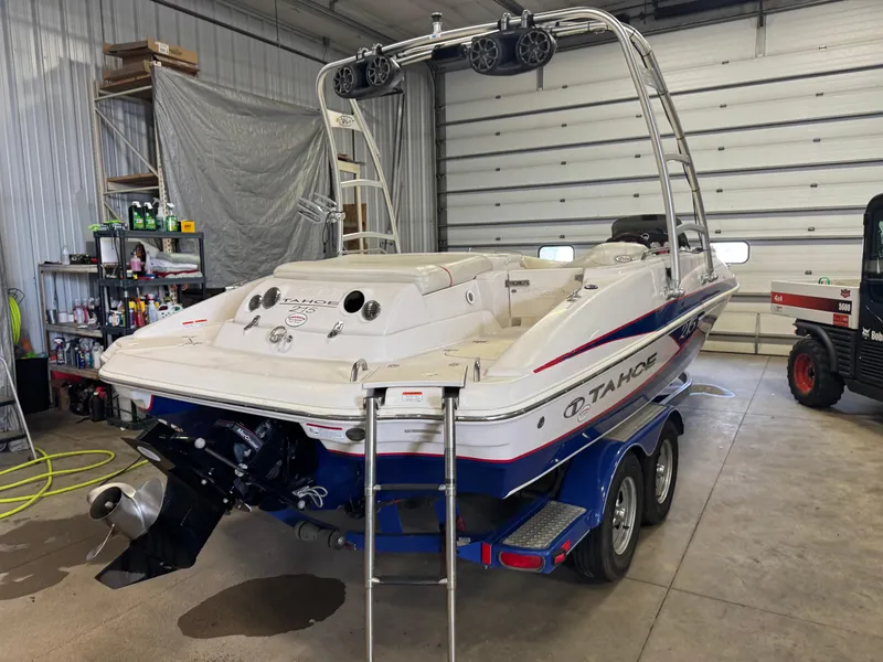 Slide: The Image of 2015 Tahoe 215 Xi boat in garage, on trailer, with wakeboard tower and outboard motor. - 3