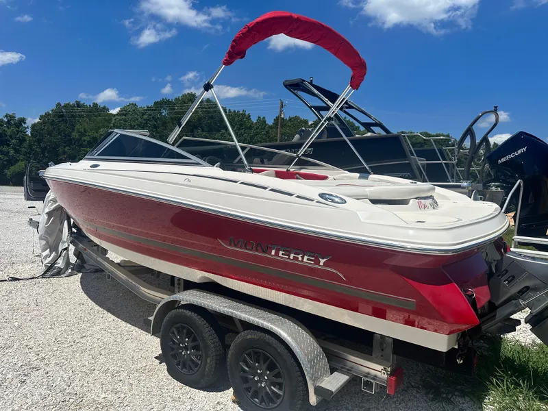 The Image of 2006 Monterey 194 FS boat with red and white design on a trailer under blue sky. - 1