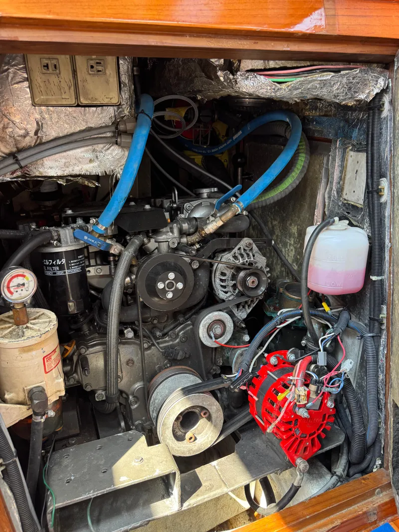 Slide: The Image of Engine compartment of a 1998 Hylas 46 sailboat, featuring various mechanical components and wiring. - 10
