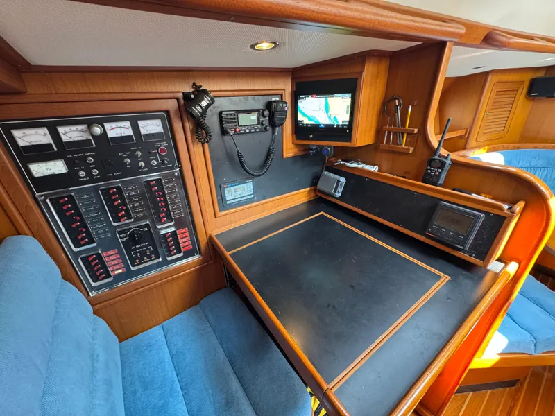Slide: The Image of Navigation station of a 1998 Hylas 46 yacht with control panels and seating. - 11