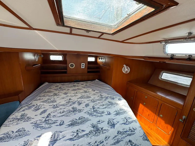 Slide: The Image of Cozy cabin interior of 1998 Hylas 46 yacht with nautical-themed bedding and wooden furnishings. - 13