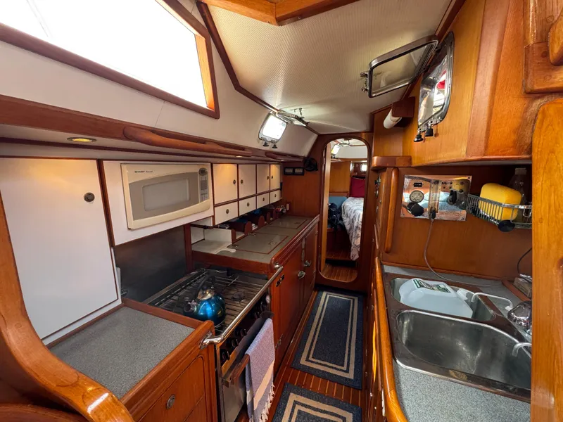 Slide: The Image of Interior of 1998 Hylas 46 yacht kitchen with wood cabinetry and modern appliances. - 17