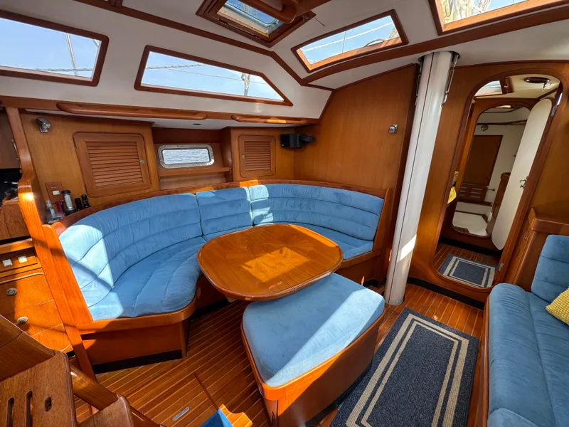 Slide: The Image of Interior of a 1998 Hylas 46 yacht with blue seating and wooden finishes. - 18