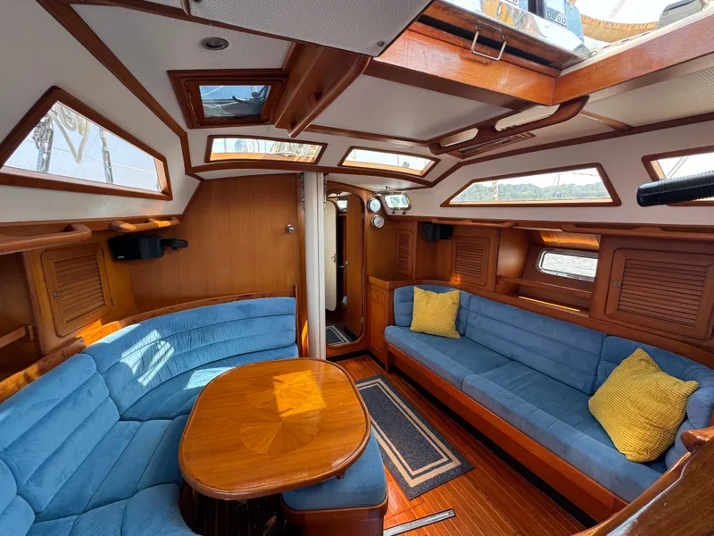 Slide: The Image of Luxurious 1998 Hylas 46 yacht interior with blue seating, wooden table, and skylights. - 19