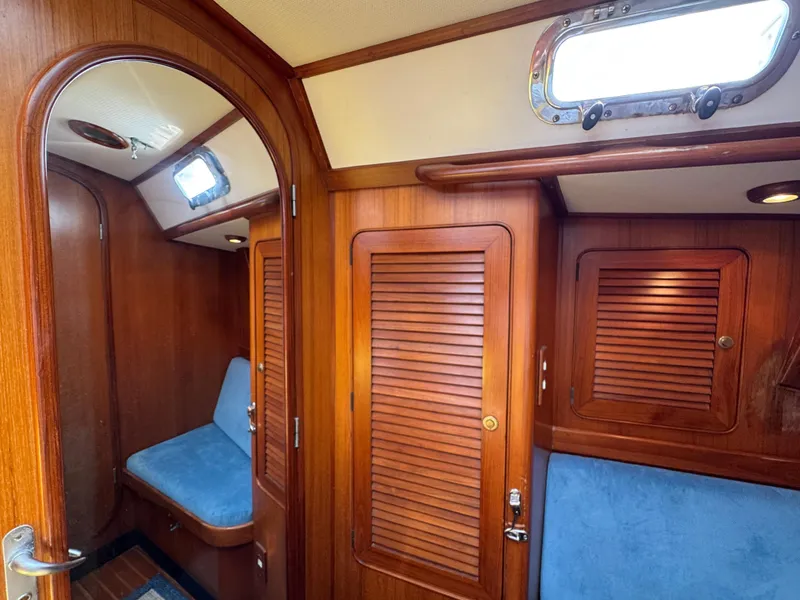 Slide: The Image of Interior of 1998 Hylas 46 yacht with wooden paneling and blue seating. - 21