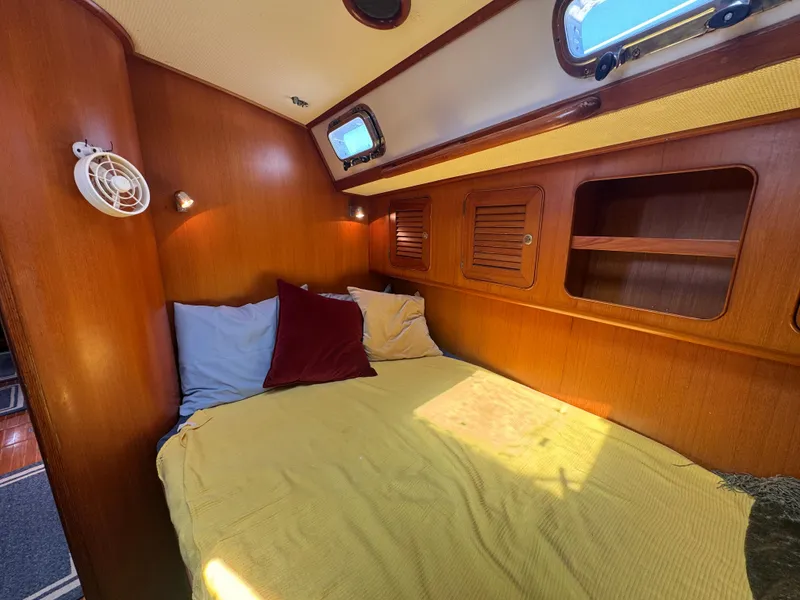 Slide: The Image of Cozy cabin interior of a 1998 Hylas 46 yacht with wooden paneling and bedding. - 23