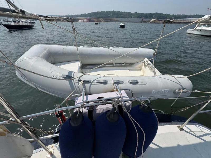 Slide: The Image of Inflatable dinghy on a 1998 Hylas 46 yacht, moored in a scenic harbor. - 7