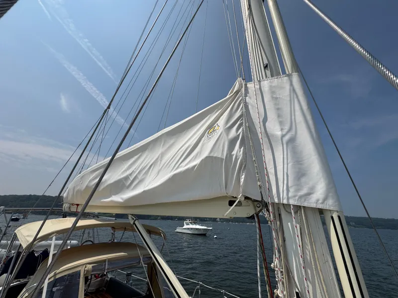 Slide: The Image of Sailboat mast and sail cover on a 1998 Hylas 46, anchored in a scenic bay. - 9