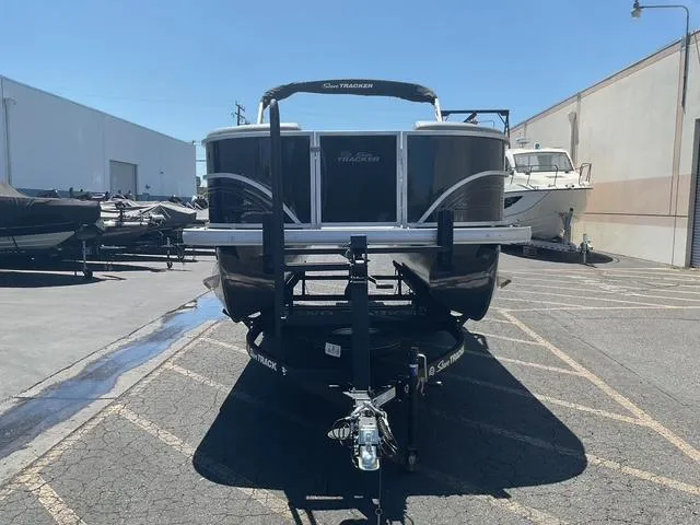 Slide: The Image of 2026 Sun Tracker Party Barge 20 DLX pontoon boat on trailer in parking lot. - 14