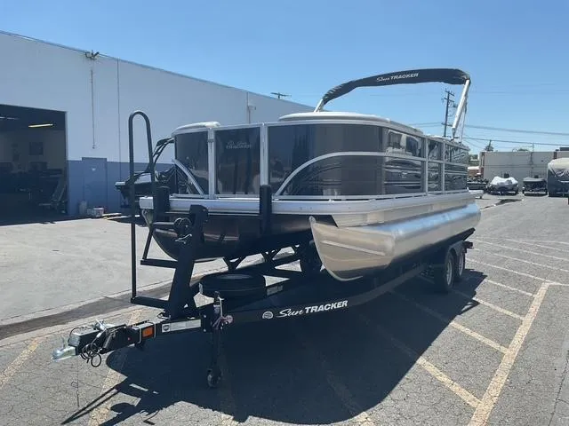 Slide: The Image of 2026 Sun Tracker Party Barge 20 DLX pontoon boat on trailer in parking lot. - 15