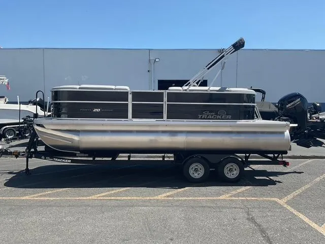 Slide: The Image of 2026 Sun Tracker Party Barge 20 DLX pontoon boat on trailer, parked outdoors. - 18