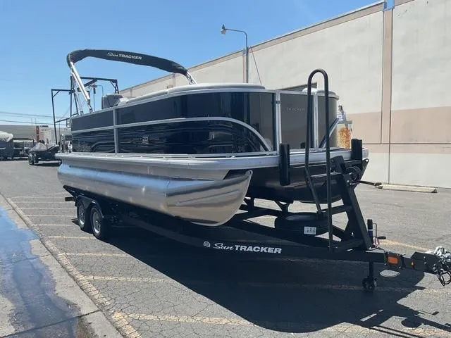 Slide: The Image of 2026 Sun Tracker Party Barge 20 DLX pontoon boat on trailer in parking lot. - 2