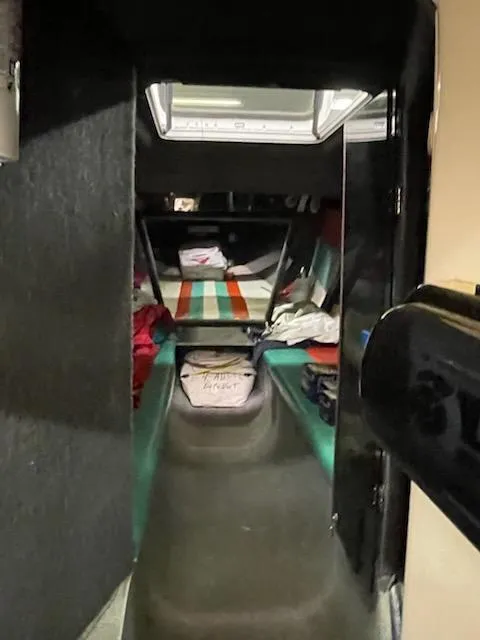 Slide: The Image of Interior cabin of a 1995 Cigarette 38 Signature Edition boat, featuring a cozy sleeping area. - 14